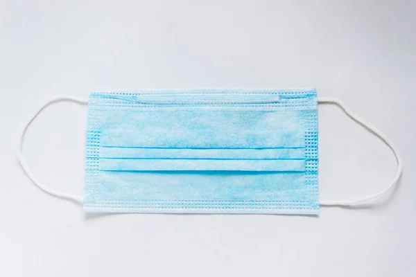 Plastik kulaklıklı cerrahi maske. Ağzı ve burnu örtmek için tipik 3 katlı cerrahi maske. Sağlık koruma kavramı..