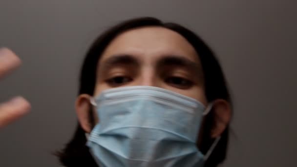 머리에 의료용 마스크나 외과용 마스크를 남자의 얼굴로 감싼다 통화중 카메라 — 비디오