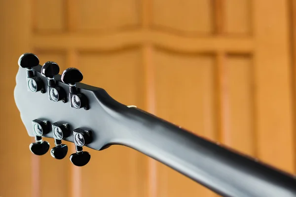 ブラックマット電気ロックギターネック屋内 木製のドアの背景 中空鋼弦アコースティックまたは半アコースティックジャズロックトップギター — ストック写真