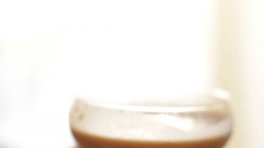 Dalgalı kahve, krem şantili kahve, latte köpüğü. İçmek yemek tarifi. Şeker kavanozu, kahve ve çiçeklerle hayat dolu. Adam kendini çikolatayla şampanyalı çay bardağı ve sütlü içecek yudumluyor.