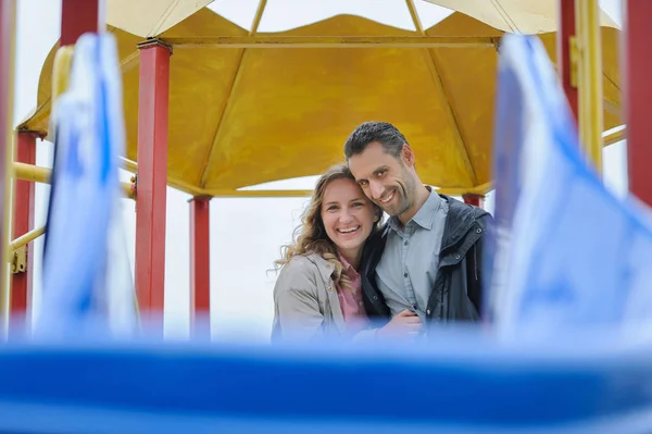 Lyckligt par att ha kul på lekplatsen tittar kameran — Stockfoto