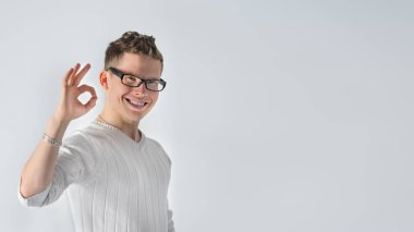 Ok işareti işaret ve gülümseyerek mutlu bir genç adam