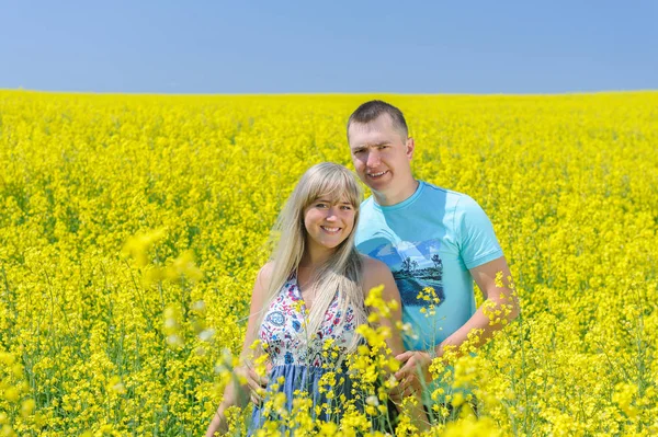 Happy couple in yellow rape field. — Stock Photo, Image