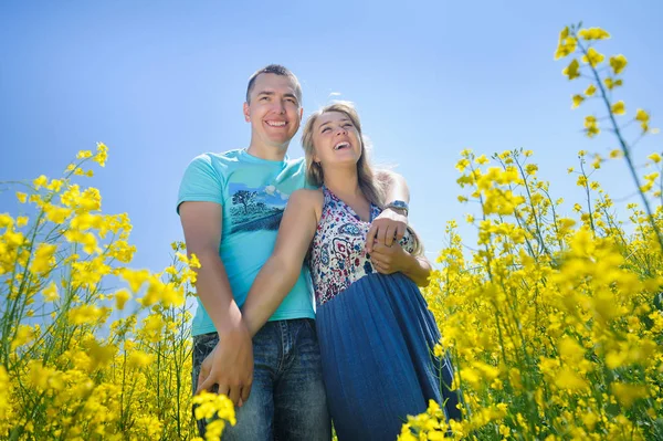 Glückliches Paar im gelben Rapsfeld. — Stockfoto