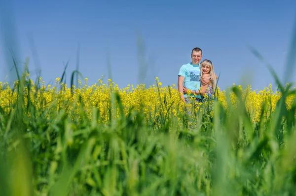 Portrait of young beautiful couple in rape field — Stock Photo, Image