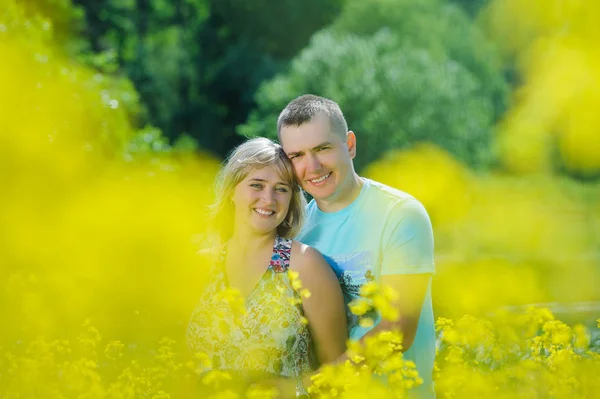 Happy couple in yellow rape field. — Stock Photo, Image