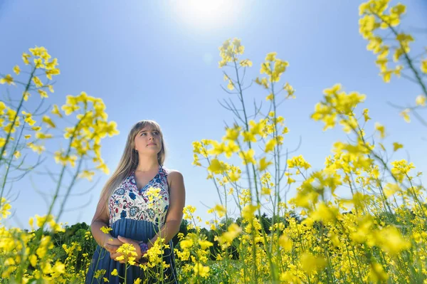 Leuke vrouw in een gele bloemen veld — Stockfoto