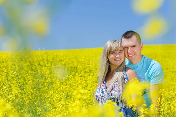 Happy couple in yellow rape field. — Stock Photo, Image