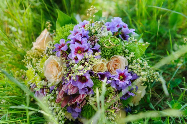 Anneaux de mariage sur bouquet de mariage en fleurs — Photo