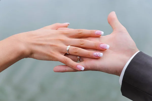 De mãos dadas com alianças de casamento — Fotografia de Stock