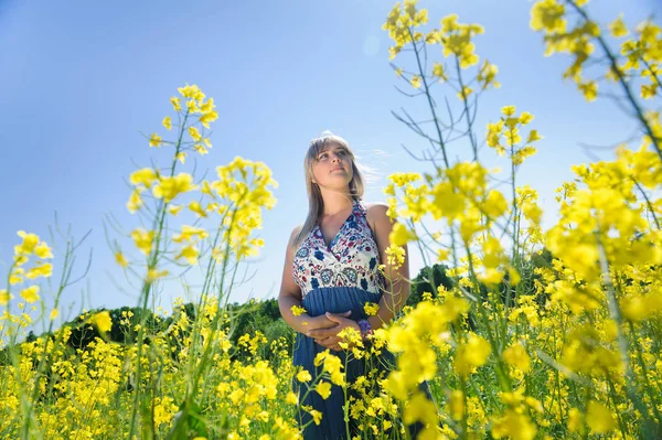 Mulher bonito em um campo de flores amarelas — Fotografia de Stock