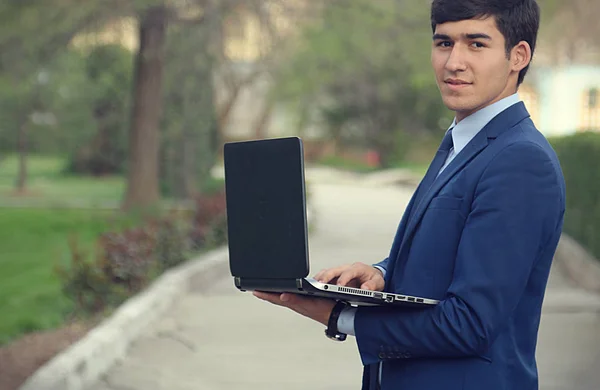 Dizüstü bilgisayarla gülümseyen iş adamı