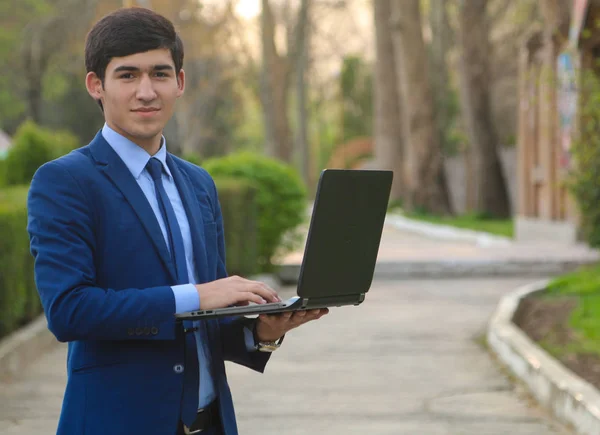 Dizüstü bilgisayarla gülümseyen iş adamı