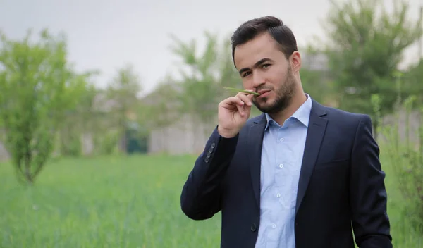 Genç bir adam portresi uyum içinde onun ağız çimen bir bıçak ile