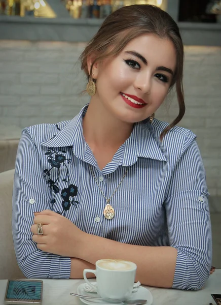 Bir kafede gülümseyen genç kız sarışın