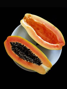 Olgun papaya siyah arka plan üzerine dilimlenmiş