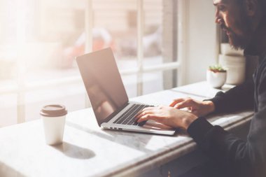 Öğle yemeği molası sırasında modern dizüstü bilgisayar kullanan çekici adam