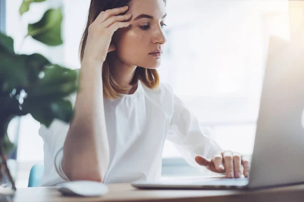 Attraktive Geschäftsfrau analysiert Monatsverkäufe auf ihrem Laptop im Büro — Stockfoto