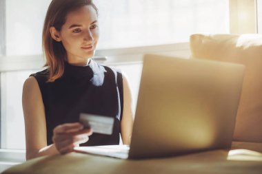İş kadını evde online alışveriş dizüstü bilgisayar ve kredi kartı kullanma