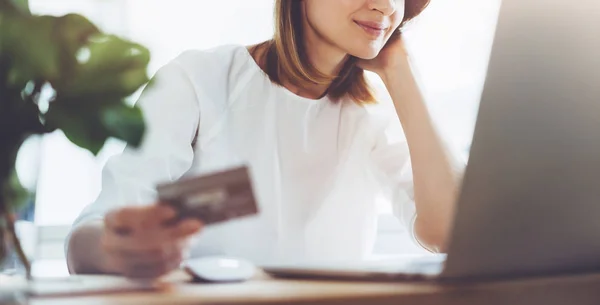 Happy woman using laptop and credit card for online shopping while lunch break in office — Stock Photo, Image