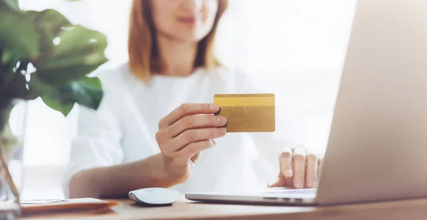 Glückliche Frau nutzt Laptop und Kreditkarte für Online-Einkäufe zu Hause — Stockfoto