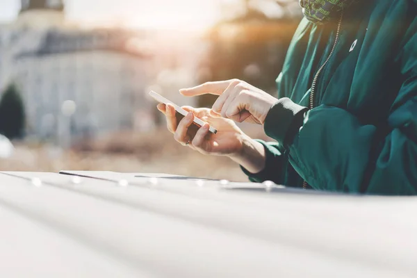 Fille pointant du doigt sur l'écran téléphone intelligent sur fond ville, Blogger SMS sur téléphone intelligent, Recherche ou réseaux sociaux concéder — Photo