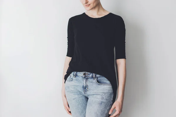 Young girl wearing blue jeans and black blank t-shirt with space for your logo or design — Stock Photo, Image