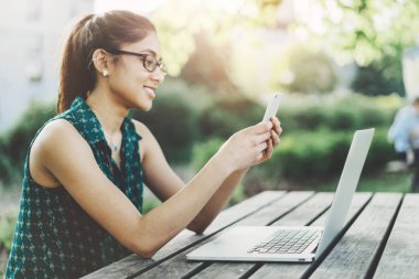 Akıllı telefon kullanan genç bir kadın. 