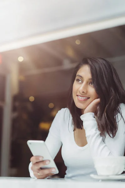 Jeune femme assise à une table — Photo