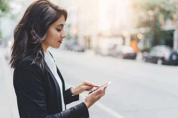 Framgångsrika kvinnliga arbetsgivare att skriva SMS på sin mobiltelefon utomhus — Stockfoto