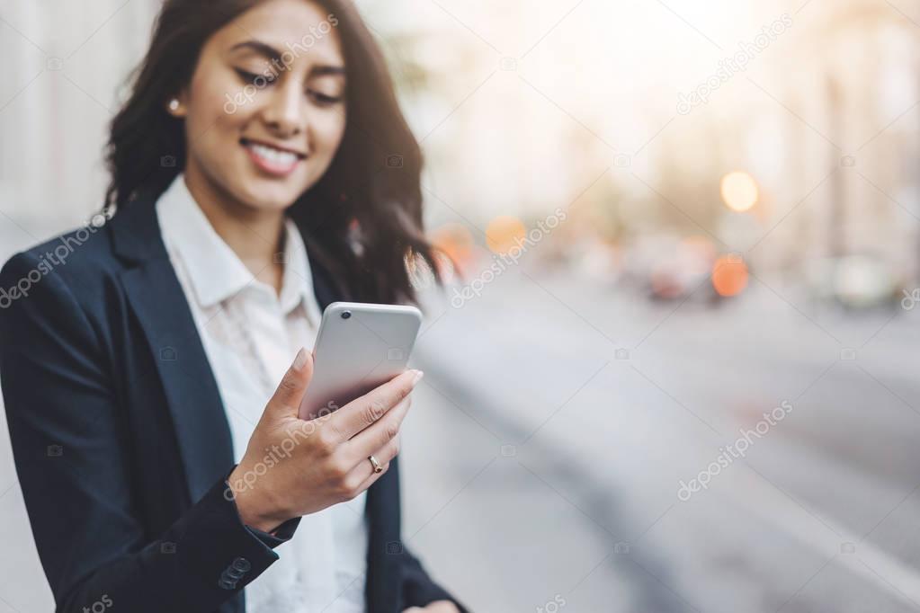 Professional manager reading information in internet via smart phone