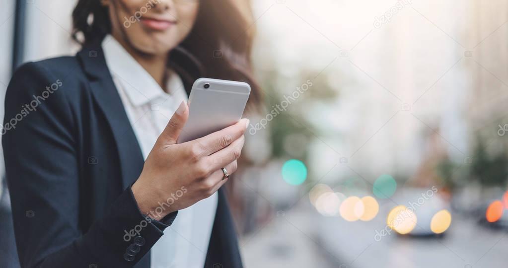 Close-up of female hand holding modern smart phone outdoor