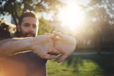 Genç adam çalıştırmadan önce vücut kasları germe