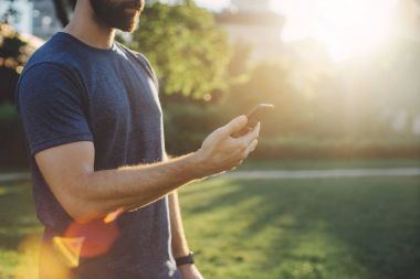 Yakışıklı adam akıllı telefon uygulama iyi egzersiz oturum sonrası onun ilerlemeyi kontrol