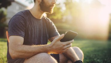 Sportif çekici adam akıllı telefon iyi egzersiz yaptıktan sonra açık kullanma