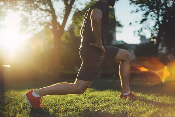 Hombre joven haciendo ejercicios de estiramiento músculos antes del entrenamiento — Foto de Stock