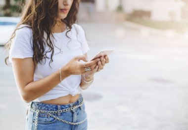 Güzel kadın kentsel bir sokakta cep telefonunda SMS tipik