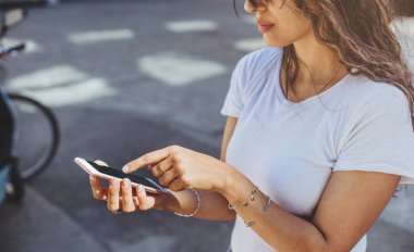 Beyaz t-shirt giyen ve modern akıllı telefon açık dokunarak genç kızın yakın çekim