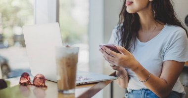 Kafede otururken dizüstü bilgisayarda çalışan profesyonel iş kadını görüntü kırpılmış 