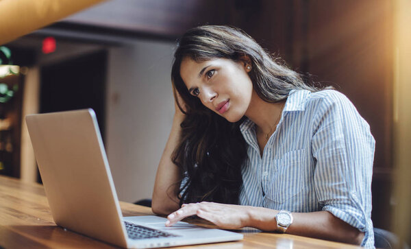 Business woman sitting by the table with laptop in office