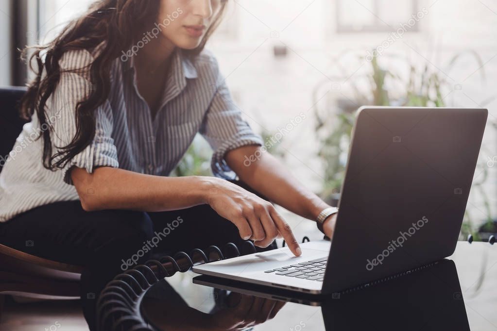 Business woman working on laptop in loft interior