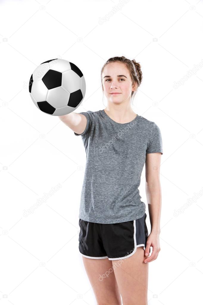 Teenage girl  holding a a soccer ball out with smile. Concept for youth sports. 