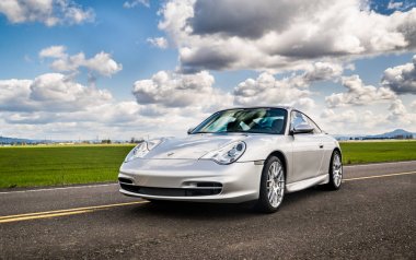 2 Nisan 2018 Eugene Oregon - gümüş bir Porsche 911'i boş bir kırsal yolda oturur.. 