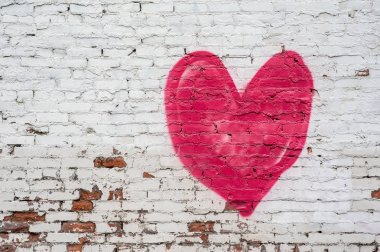 Bir sıkıntılı beyaz tuğla duvar kırmızı kalp.