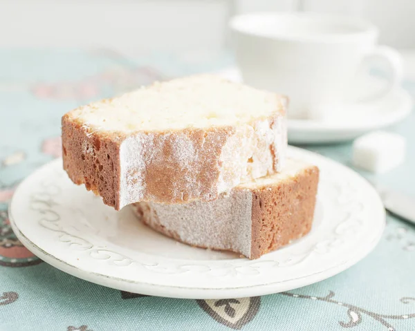 Gâteau fait maison powedered sur une serviette cyan avec des fleurs et fond blanc . — Photo