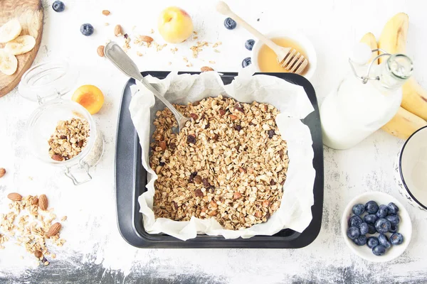 Granola meyve ve süt ile bir çerez levha üzerine.