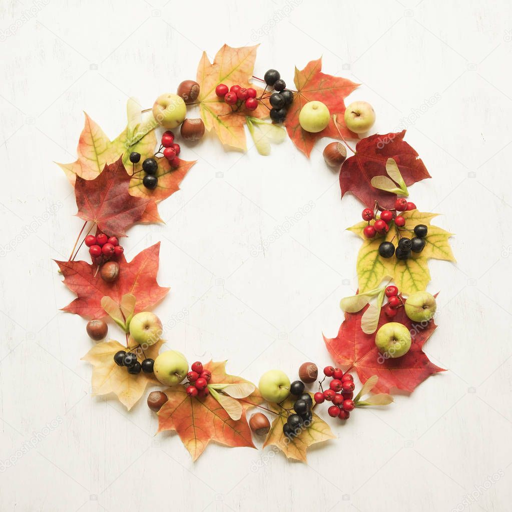 Wreath made of autumn leaves, berries, apples and nuts.