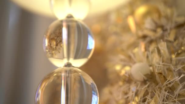 白色和金色的圣诞装饰点缀在明亮的灯火背景上 美丽的新年树 长着小球 家里还有白色的蜡烛和黄色的花环 — 图库视频影像