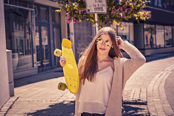 En pige med skateboard - Stock-foto