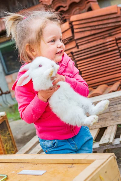 Kleines Mädchen Mit Kaninchen Vor Dem Bauernhof — Stockfoto